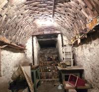 Hagyományos pince egy családi házban, tele befőttekkel és antik bútorokkal.