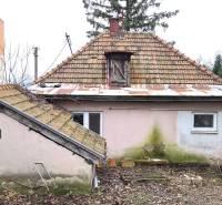 Családi ház az Augusztus 29. utcában, Lévában, kopott homlokzattal és kerttel.