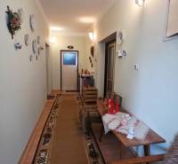 Családi ház folyosója dekoratív tányérokkal a falon és szőnyeggel.