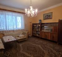 Nappali családi házban csillárral és bútorokkal, padló dekoratív szőnyeggel.