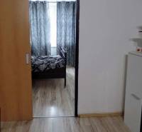 Belső tér fa dekor padlóval, posuvnými dvermi a čiernobielymi závesmi v 3-izbovom byte.