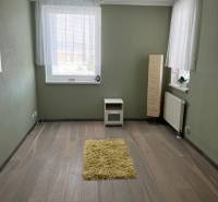 Szoba egy 4 szobás lakásban, fa dekor padlóval és zöld falakkal.