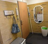 Négy szobás lakás előszobája fogassal, paddal és tükörrel.