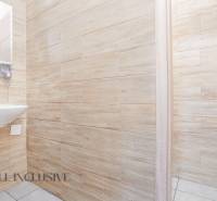 Iroda belső mosdóval, fa falakkal és nyitott ajtókkal.