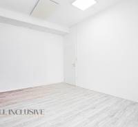 Fehér falakkal és fa dekorációjú padlóval rendelkező belső tér egy irodában.