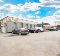 Épületek a Galántai Clementis Ligetben irodák előtt parkoló járművekkel.