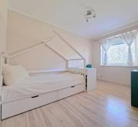 Gyerekszoba családi házban, házikó alakú ággyal és fa dekorációjú padlóval.