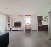 Nappali TV-vel, konyhával és étkezőasztallal, fa dekoros padlóval.