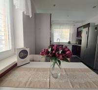 Konyha egy családi házban, tulipánokkal az asztalon és fehér függönyökkel.