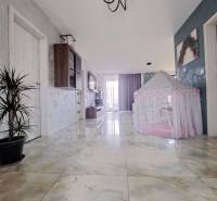 Folyosó egy családi házban fényes csempével és gyerek sátorral.