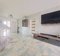 Nappali családi házban, falra szerelt televízióval, sátorral és kerámia padlóval.