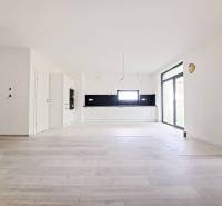 Tágas konyha fekete burkolattal és fa dekorációjú padlóval egy családi házban.