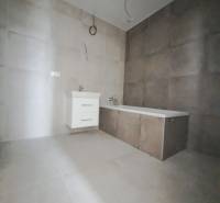 Fürdőszoba családi házban burkolattal és káddal semleges padlólapon.