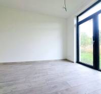 Egy üres szoba nagy ablakkal és fa dekorációjú padlóval egy családi házban.