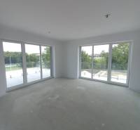 Nagy ablakok és természetes fény a kétszobás lakásban, kilátással a zöldre.