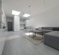 Nappali kanapéval, fa dekor padlóval és étkezőasztallal egy kétszobás lakásban.