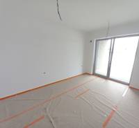 Kereskedelmi helyiségek nagy ablakkal, fehér festés, fa dekorációjú padló fóliával letakarva.