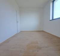 Családi ház belső tere világos szobával, fa dekorú padlóval, nagy ablakkal.