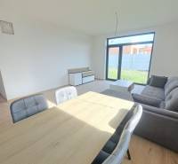 Ebédlő egy családi házban kanapéval és fa dekor padlóval.