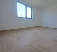 Tágas szoba fa dekor padlóval és nagy ablakkal egy családi házban.