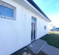 Családi ház Galántán, fehér homlokzattal és térkővel a előkertben.