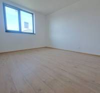 Szoba egy családi házban fa dekoros padlóval és nagy ablakkal.