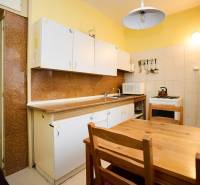 Konyha egy háromszobás lakásban, faasztallal. Szekrények, tűzhely, hűtőszekrény mágnesekkel.