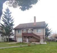 Családi ház Dunaszerdahelyen, ferde tető, tágas kert, külső lépcső.