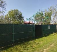 Zöld terület a kertekben Sároson, napos nap kék éggel.