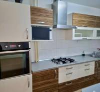 Konyha kőedény mosogatóval, főzőlappal és páraelszívóval egy 4 szobás lakásban.