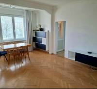 Ebédlő faasztallal és székekkel, fa dekoros padló egy 4 szobás lakásban.