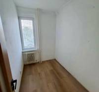 Kis szoba fa dekor padlóval egy 4 szobás lakásban, fény az ablakból.