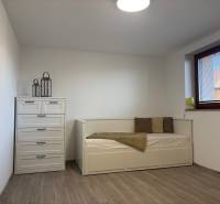 Szoba családi házban ággyal, komóddal és fa dekor padlóval.