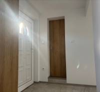 Családi ház belső tere fehér ajtókkal és fa dekorációjú padlóval.