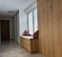 Folyosó családi házban fogasokkal és párnás üléssel, fa mintázatú padlóval.