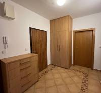 Előszoba egy háromszobás lakásban, csempével és fa dekorációjú szekrényekkel.