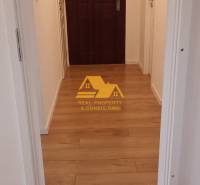 Keskeny folyosó bejárati ajtóval és fa dekorációjú padlóval egy kétszobás lakásban.