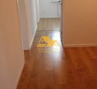 Folyosó fa dekor padlóval egy kétszobás lakásban, semleges falak.