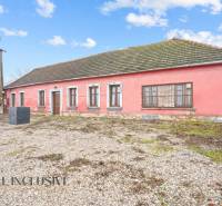 Családi ház Sempteben kőalappal, rózsaszín homlokzattal és fa ablakokkal.