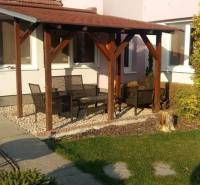 Családi ház Feketevízen terasszal, kerti bútorokkal és zöld gyepfelülettel.