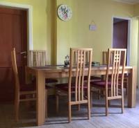 Ebédlő egy családi házban, székekkel és asztallal, fa dekorációjú padlón.