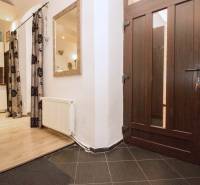 A kétszobás lakásban van egy bejárati folyosó fa dekor padlóval és egy nyitott konyhával.