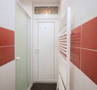 Fürdőszoba egy kétszobás lakásban piros csempével és fehér ajtókkal.