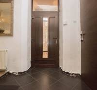 Bejárati folyosó sötét ajtókkal, tükörrel és radiátorral egy kétszobás lakásban.