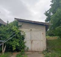 Családi ház Strekovban, kis fészerrel, zölddel és fákkal körülvéve.