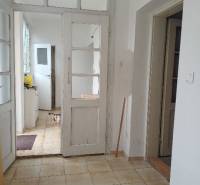 Családi ház belső tere fehér ajtókkal és csempézett padlóval.