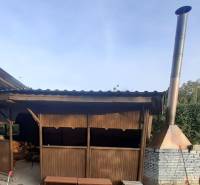 Fa pavilon és téglakémény a házikó mellett Pozdišovce-ben.