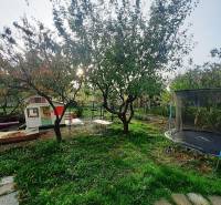 Kert a pozdišovcei háznál házikóval, hintával és trambulinnal.