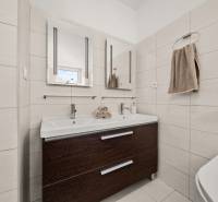 Fürdőszoba családi házban dupla mosdóval és sötét szekrénnyel.