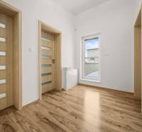 Családi ház belső tere fa dekorációjú padlóval és üvegezett ajtókkal.